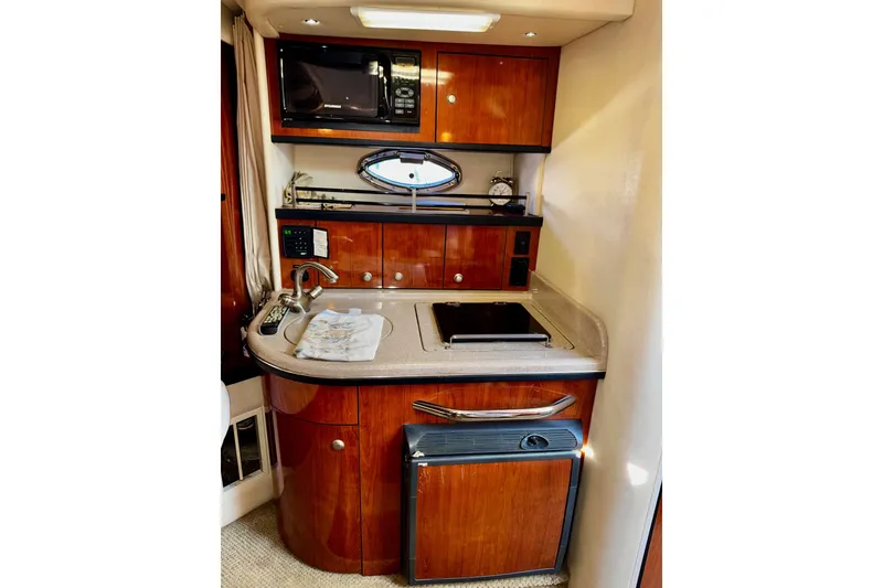 Slide: The Image of 2007 Sea Ray 290 Sundancer galley with microwave, sink, and compact fridge. - 23