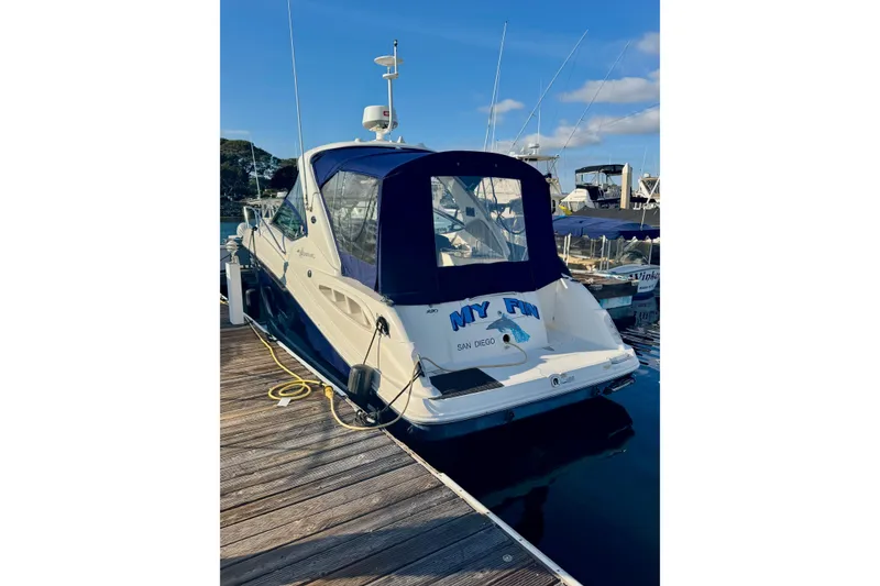 Slide: The Image of 2007 Sea Ray 290 Sundancer docked at marina, rear view with blue canopy. - 5