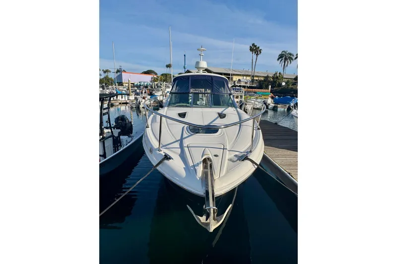 Slide: The Image of 2007 Sea Ray 290 Sundancer docked at marina, clear sky, palm trees in background. - 8