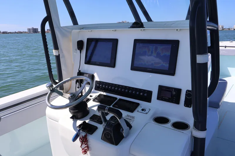 Slide: The Image of 2017 Contender 35 ST boat dashboard with navigation screens and steering wheel on open water. - 13