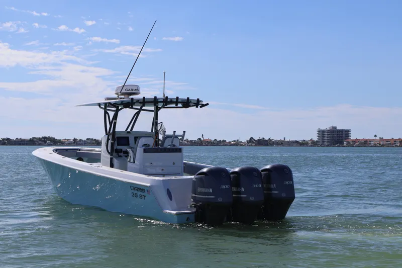 Slide: The Image of 2017 Contender 35 ST boat with triple Yamaha engines on calm water. - 2