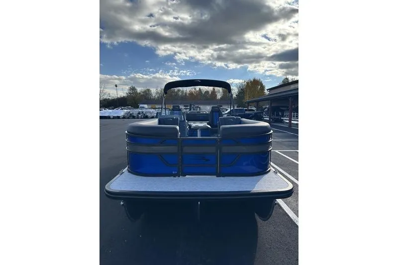 Slide: The Image of 2026 Bennington S Swingback 22 SSB pontoon boat, blue exterior, parked outdoors under cloudy sky. - 7