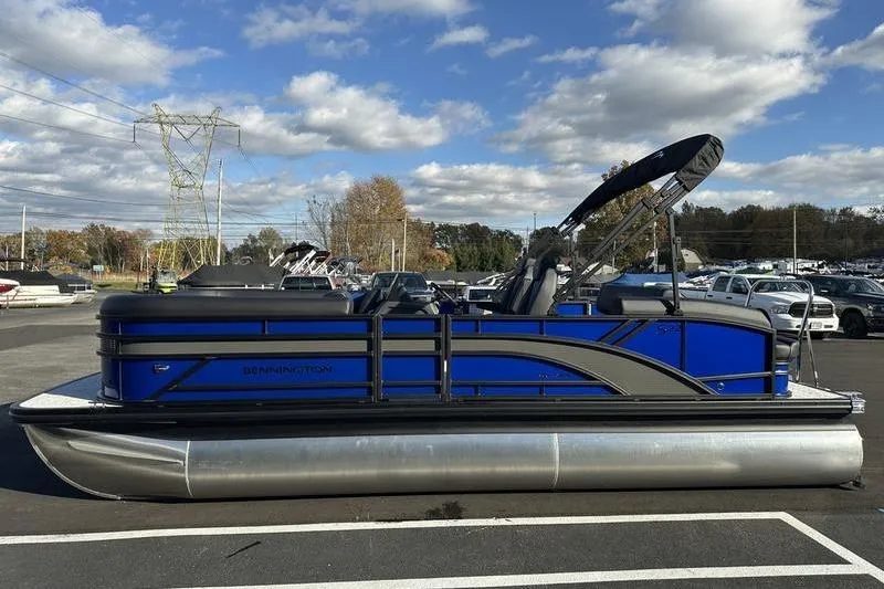Slide: The Image of 2026 Bennington S Swingback 22 SSB pontoon boat in a parking lot under a cloudy sky. - 9