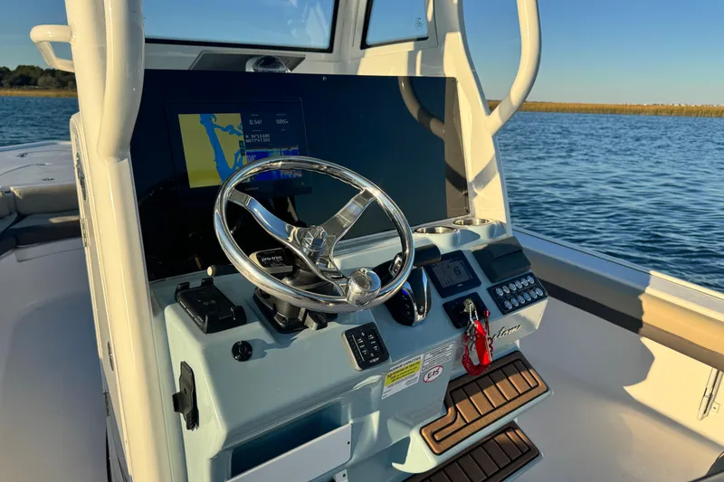 Slide: The Image of 2023 Tidewater 2500 Carolina Bay boat console with steering wheel and navigation display. - 17