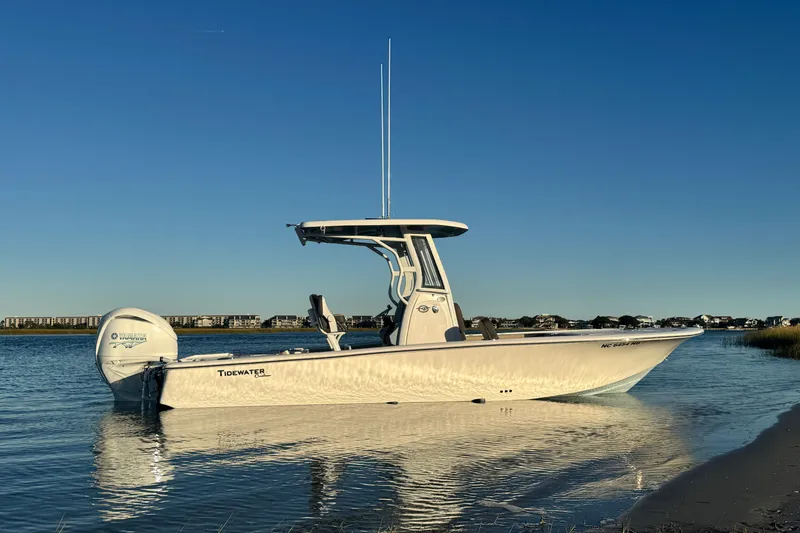 Slide: The Image of 2023 Tidewater 2500 Carolina Bay boat on calm water under clear blue sky. - 3