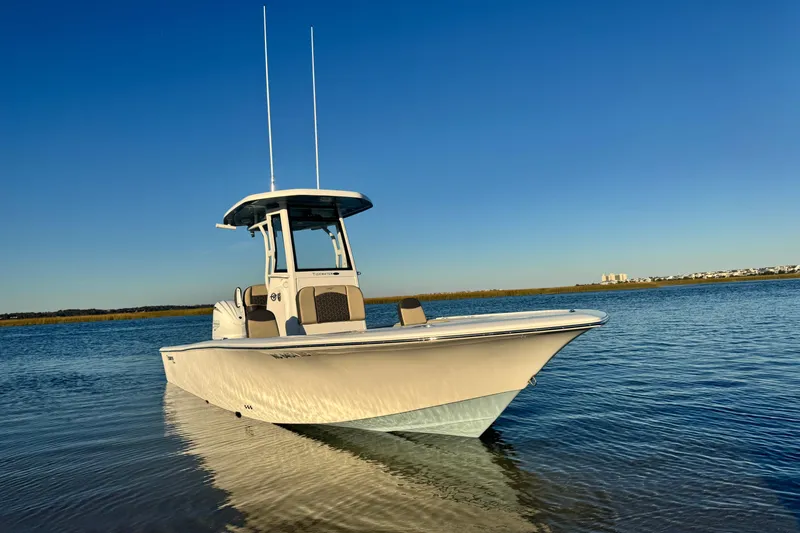 Slide: The Image of 2023 Tidewater 2500 Carolina Bay boat on calm water under clear blue sky. - 4
