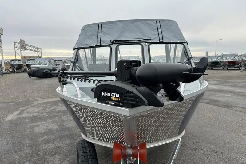 Slide: The Image of 2025 Hewescraft 160 Sportsman boat with Minn Kota Terrova motor, parked outdoors. - 3