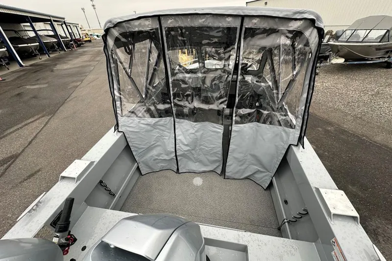 Slide: The Image of 2025 Hewescraft 160 Sportsman boat with protective canopy, parked in a marina. - 5