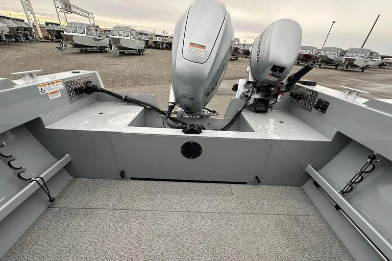Slide: The Image of 2025 Hewescraft 160 Sportsman boat with dual outboard motors, parked in a marina. - 9