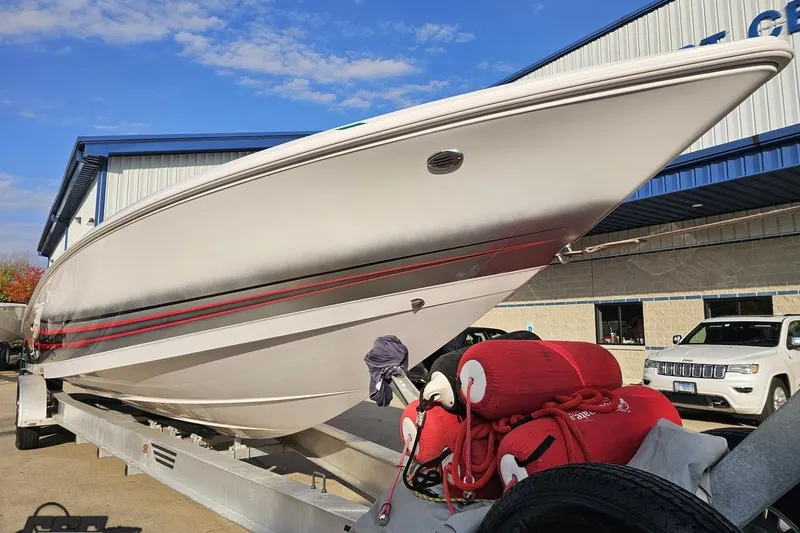 Slide: The Image of 2008 Donzi 38 ZR boat on trailer, white with red accents, parked outdoors. - 14