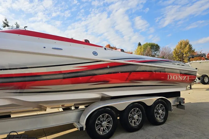 Slide: The Image of 2008 Donzi 38 ZR speedboat with red and white design on a trailer under blue sky. - 20