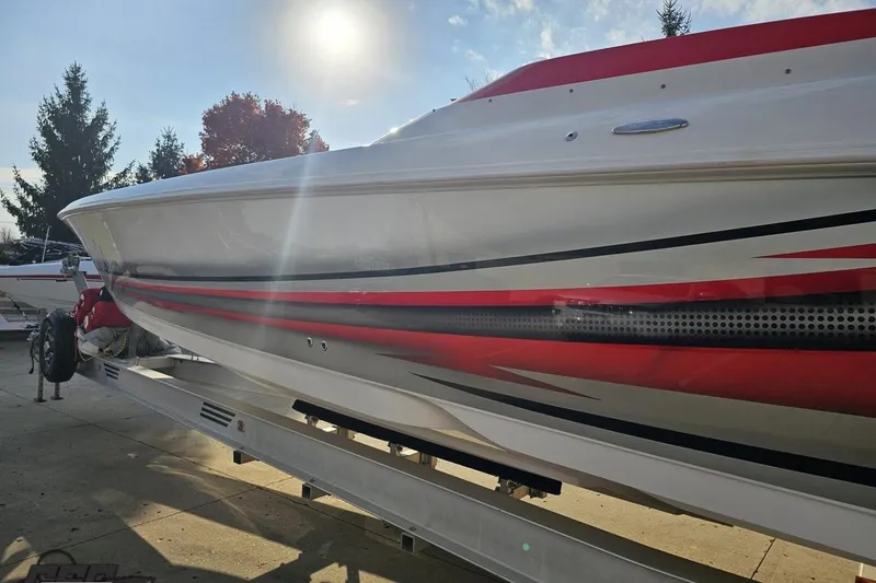 Slide: The Image of 2008 Donzi 38 ZR boat with red and white design on a trailer under sunlight. - 23