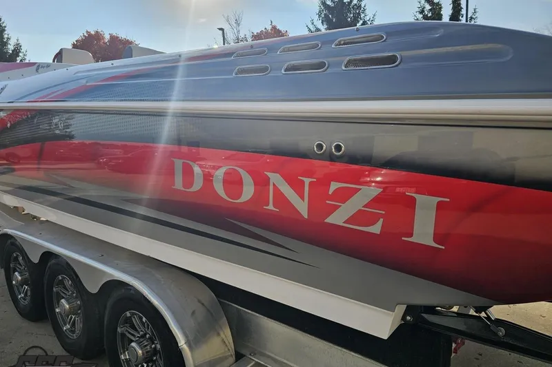 Slide: The Image of 2008 Donzi 38 ZR speedboat with red and gray design on a trailer. - 26