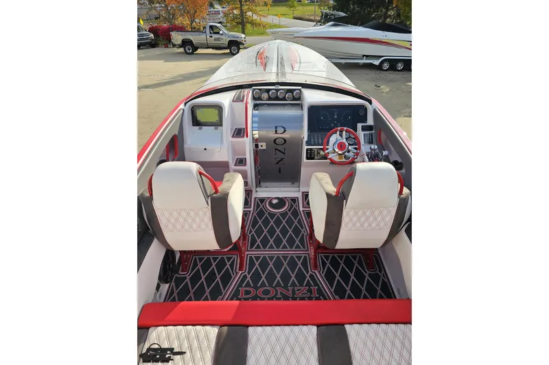 Slide: The Image of 2008 Donzi 38 ZR boat cockpit with red and white seating, steering wheel, and dashboard. - 37