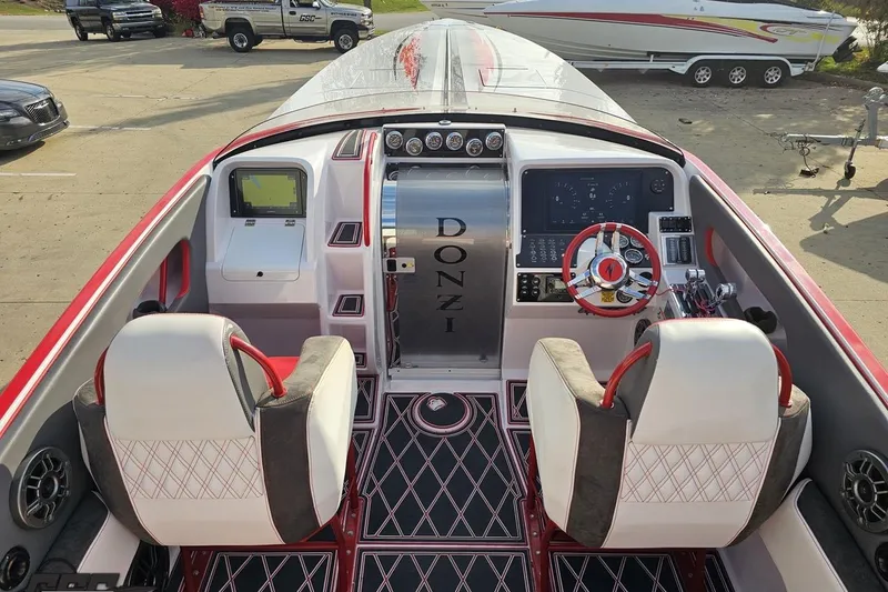 Slide: The Image of 2008 Donzi 38 ZR boat interior with red accents and modern dashboard controls. - 38
