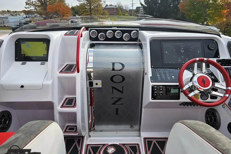 Slide: The Image of 2008 Donzi 38 ZR boat cockpit with modern controls and red-accented steering wheel. - 47