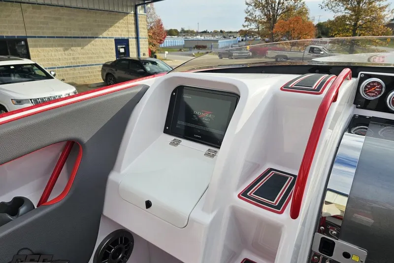 Slide: The Image of 2008 Donzi 38 ZR boat dashboard with navigation screen and red accents. - 49