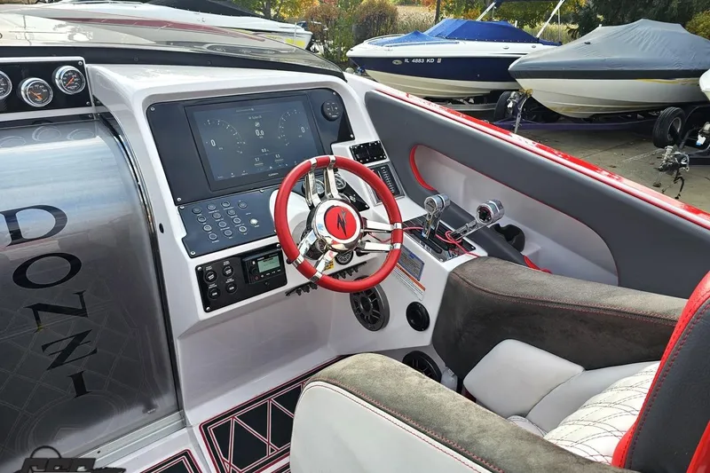 Slide: The Image of 2008 Donzi 38 ZR boat cockpit with modern controls and red-accented steering wheel. - 54