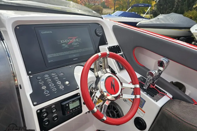 Slide: The Image of 2008 Donzi 38 ZR boat dashboard with Garmin display and red steering wheel. - 55