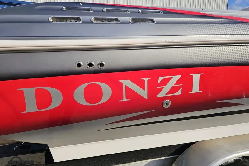 Slide: The Image of 2008 Donzi 38 ZR boat with red and gray detailing, close-up view. - 8