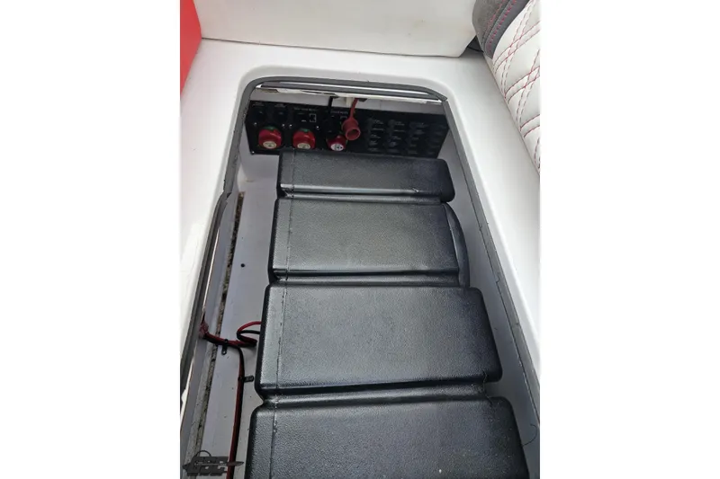 Slide: The Image of 2008 Donzi 38 ZR battery compartment with black covers and wiring. - 89