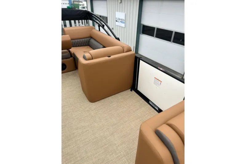 Slide: The Image of 2026 Harris CRUISER 230 SL boat interior with tan seating and beige flooring. - 18
