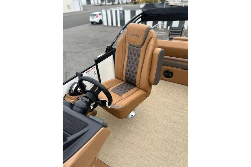 Slide: The Image of 2026 Harris CRUISER 230 SL boat interior with luxurious tan captain's chair and steering wheel. - 25