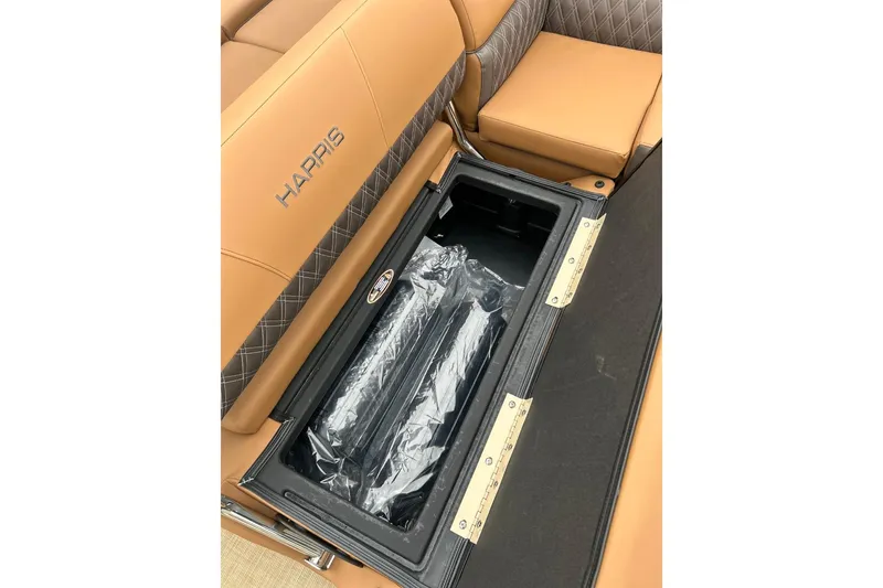 Slide: The Image of 2026 Harris CRUISER 230 SL boat seat storage compartment with tan upholstery. - 35