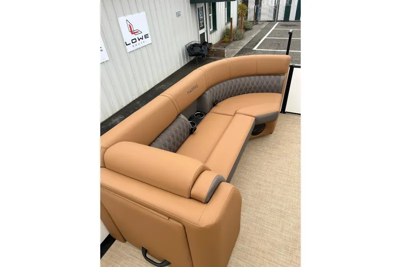 Slide: The Image of Luxurious seating on 2026 Harris CRUISER 230 SL boat, featuring tan upholstery and cup holders. - 38