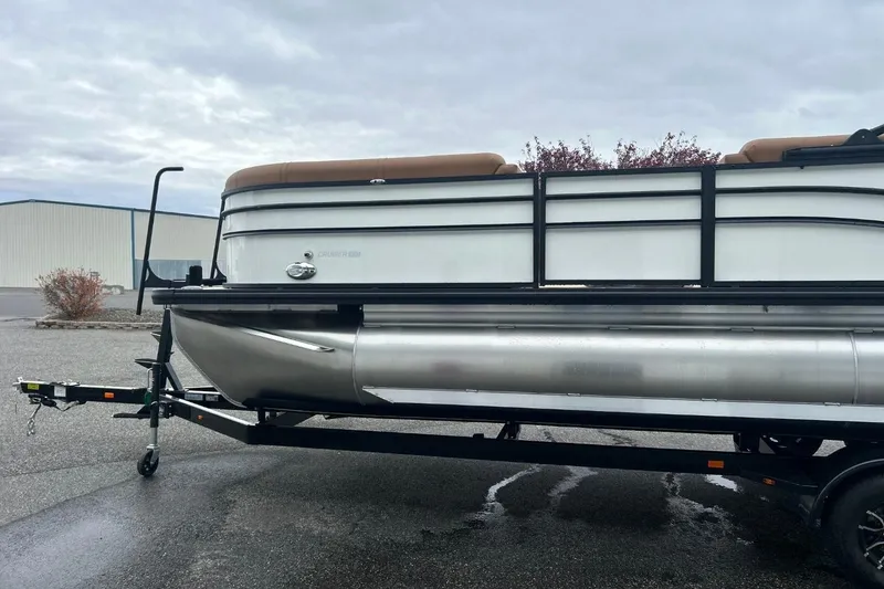 Slide: The Image of 2026 Harris CRUISER 230 SL pontoon boat on trailer, parked outdoors on overcast day. - 5