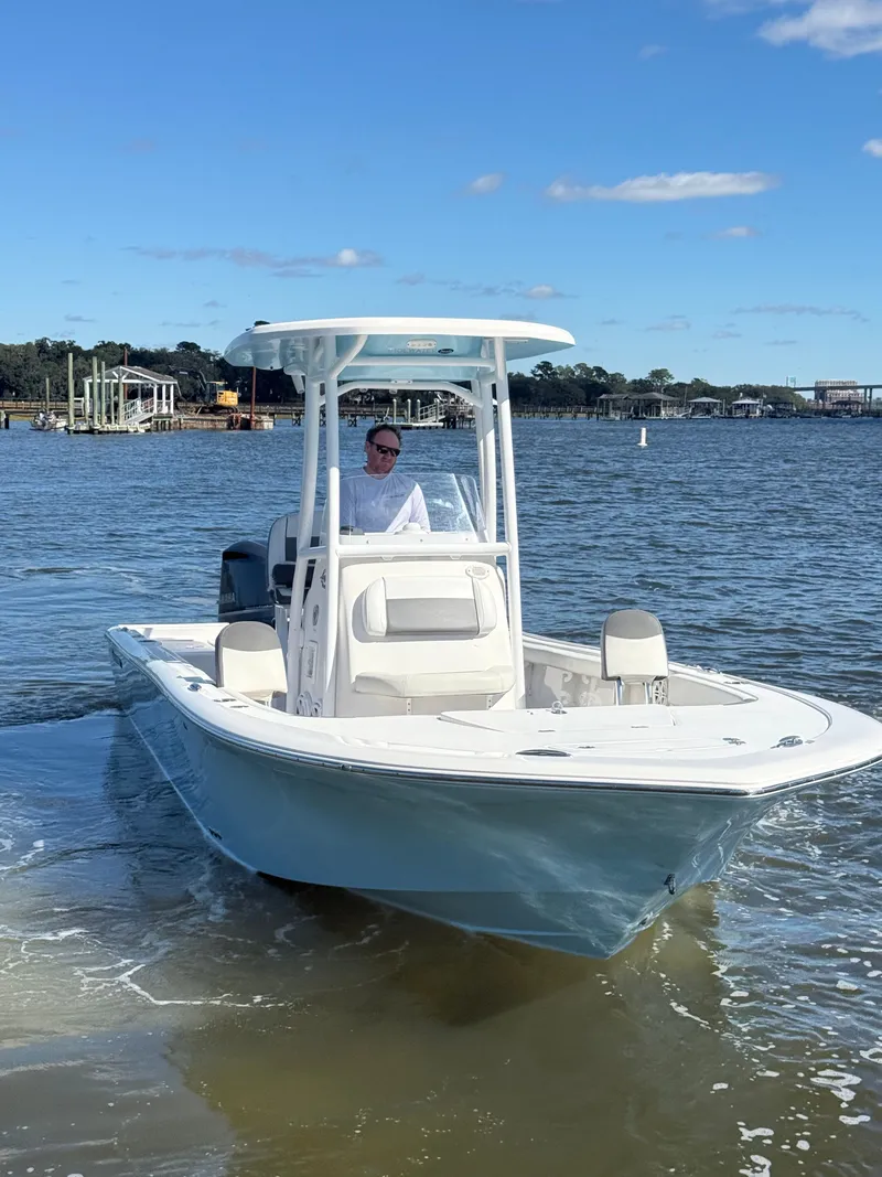 Slide: The Image of 2020 Tidewater 2300 Carolina Bay boat on water, clear sky, person at helm. - 22
