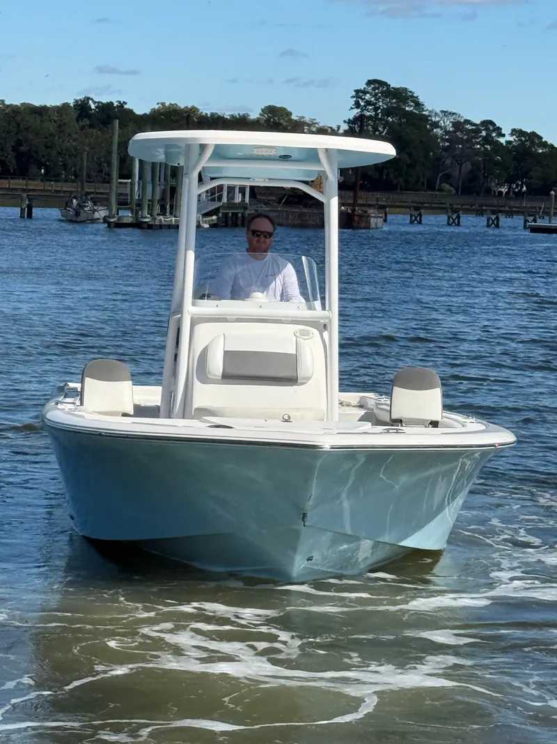 Slide: The Image of 2020 Tidewater 2300 Carolina Bay boat on water with person at helm. - 3
