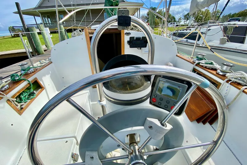 Slide: The Image of 1986 Bayfield 32 sailboat cockpit with steering wheel and navigation equipment. - 11