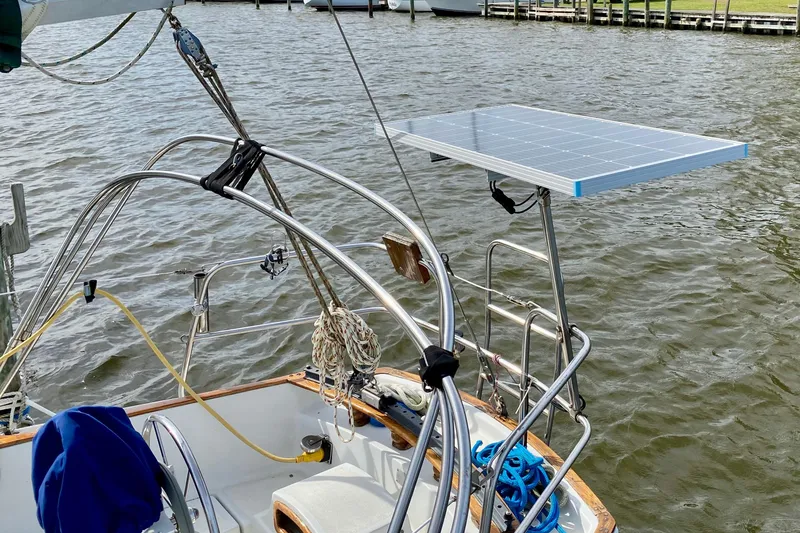 Slide: The Image of 1986 Bayfield 32 sailboat with solar panel, docked on calm water. - 14
