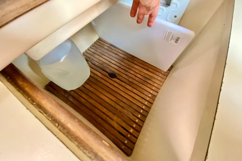 Slide: The Image of Storage compartment in 1986 Bayfield 32 sailboat with wooden slats and a plastic jug. - 24