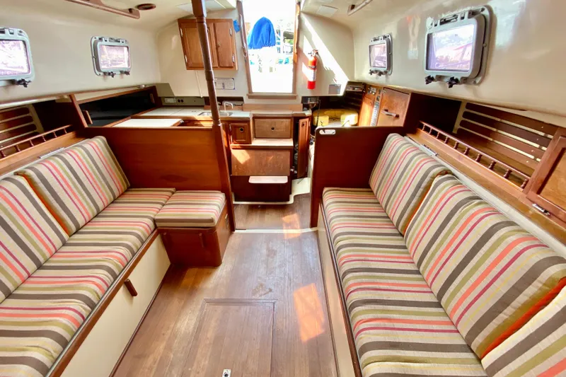Slide: The Image of Interior of a 1986 Bayfield 32 sailboat with striped seating and wooden finishes. - 26