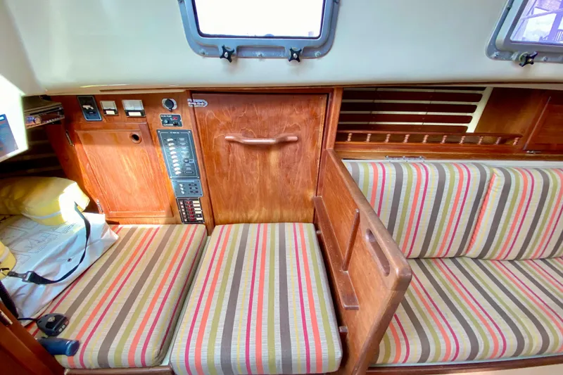 Slide: The Image of 1986 Bayfield 32 sailboat interior with striped cushions and wooden paneling. - 27