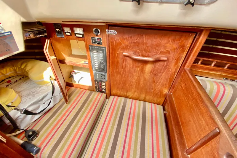 Slide: The Image of Interior of 1986 Bayfield 32 sailboat with wood paneling and striped cushions. - 28