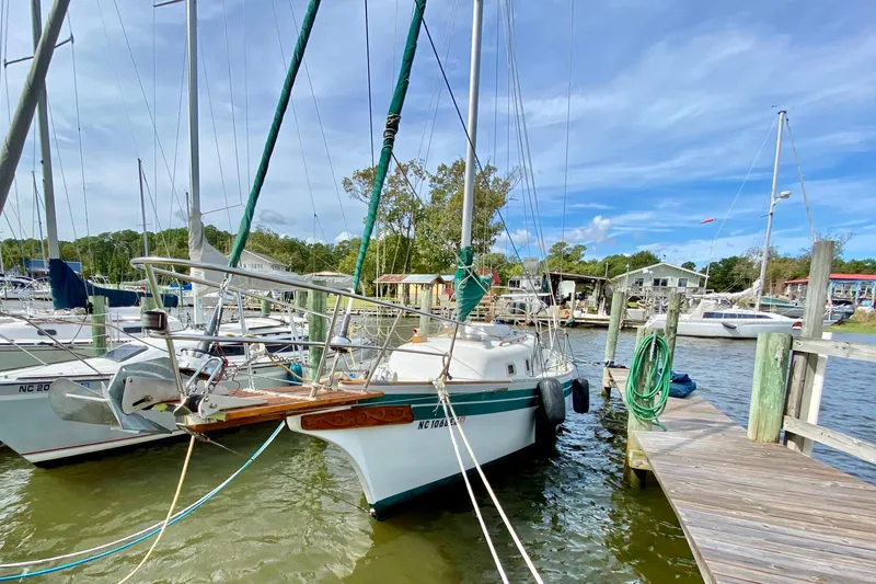 Slide: The Image of 1986 Bayfield 32 sailboat docked at a marina under a clear blue sky. - 3
