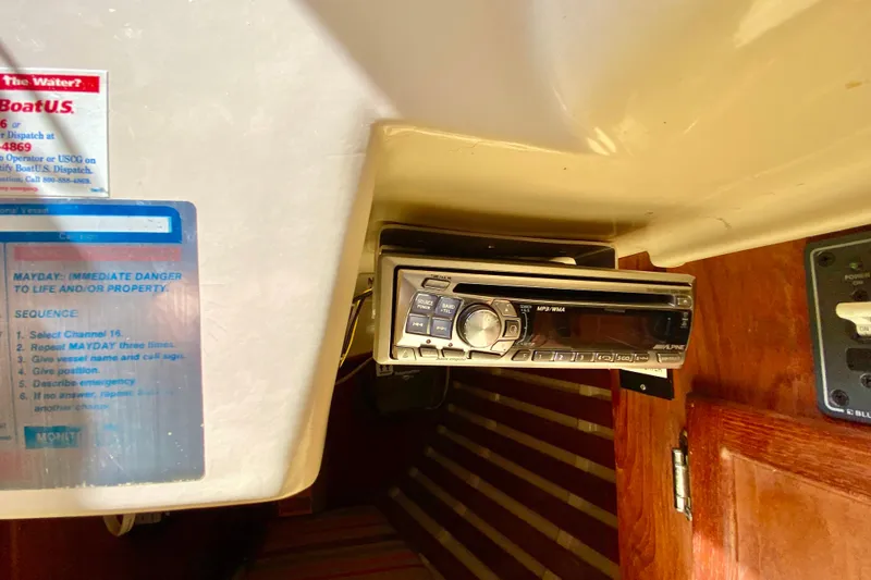 Slide: The Image of 1986 Bayfield 32 interior with Alpine stereo and emergency instructions. - 32