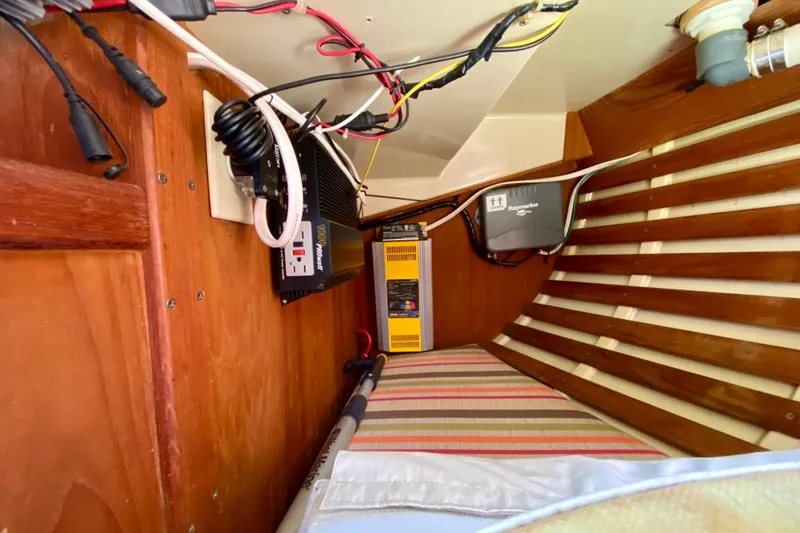 Slide: The Image of Electrical setup inside a 1986 Bayfield 32 boat, featuring wiring and equipment. - 33