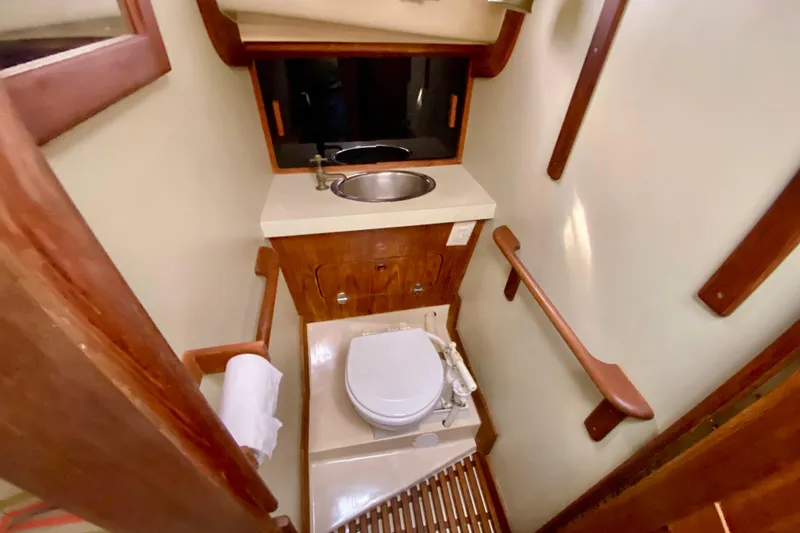 Slide: The Image of Compact bathroom in 1986 Bayfield 32 sailboat with toilet, sink, and wooden accents. - 38