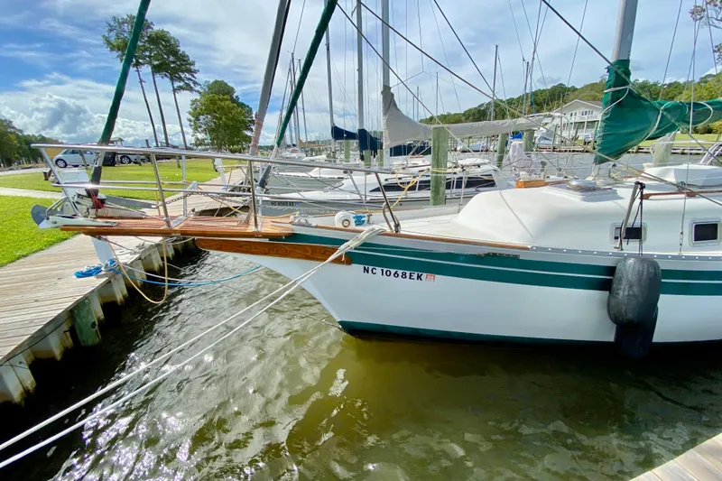 Slide: The Image of 1986 Bayfield 32 sailboat docked at marina, featuring green accents and wooden bowsprit. - 4