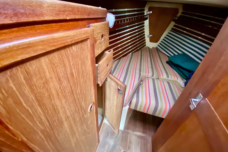 Slide: The Image of Interior cabin of 1986 Bayfield 32 sailboat with striped bedding and wooden cabinetry. - 40