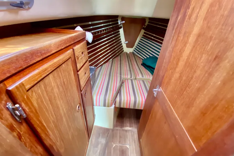 Slide: The Image of Cozy cabin interior of 1986 Bayfield 32 sailboat with striped cushions and wooden cabinetry. - 41