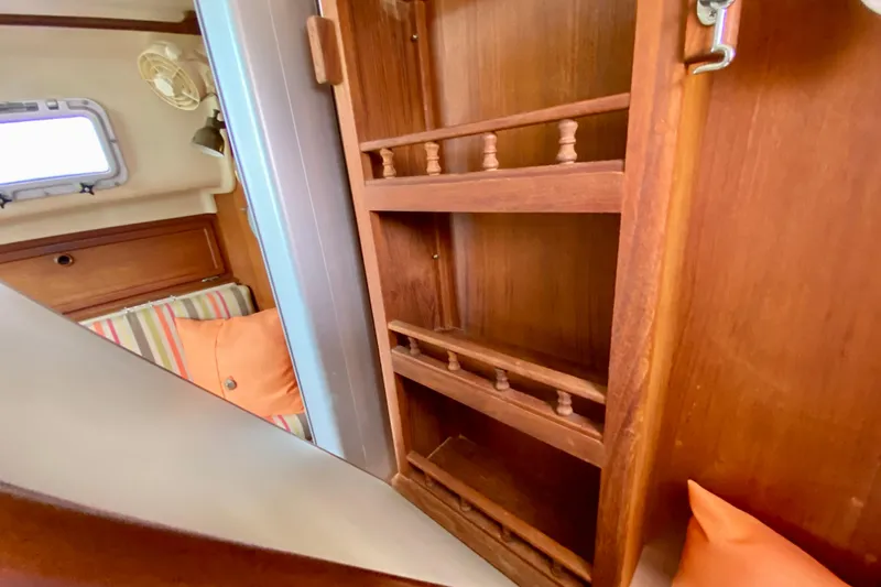 Slide: The Image of Interior of 1986 Bayfield 32 sailboat with wooden shelves and striped cushions. - 44