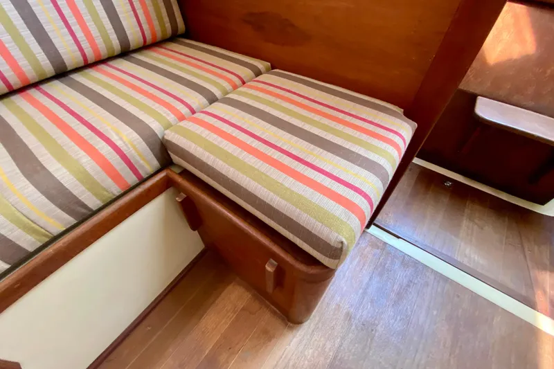Slide: The Image of Striped cushions on wooden seating inside a 1986 Bayfield 32 boat interior. - 46