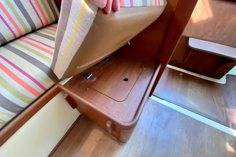 Slide: The Image of 1986 Bayfield 32 interior with striped cushions and wooden storage compartment. - 47