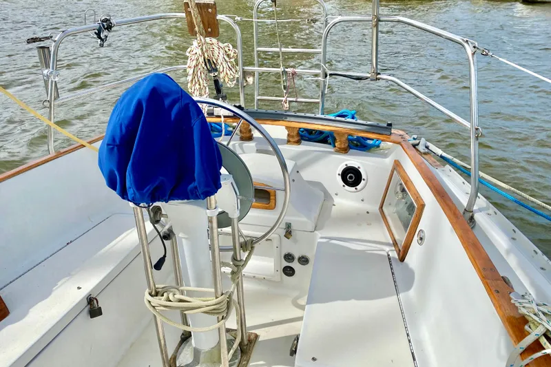 Slide: The Image of Cockpit of 1986 Bayfield 32 sailboat with blue-covered helm and wooden accents. - 7