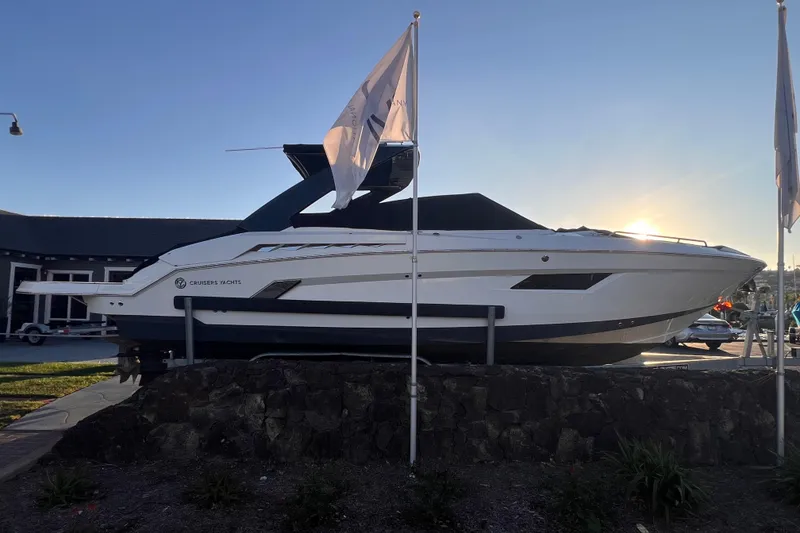Slide: The Image of 2019 Cruisers Yachts 338 Bow Rider displayed outdoors at sunset. - 2